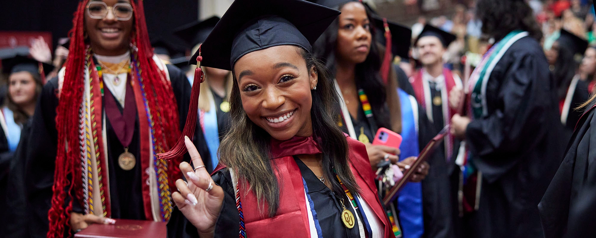 Graduates celebrating during college convocation ceremony.