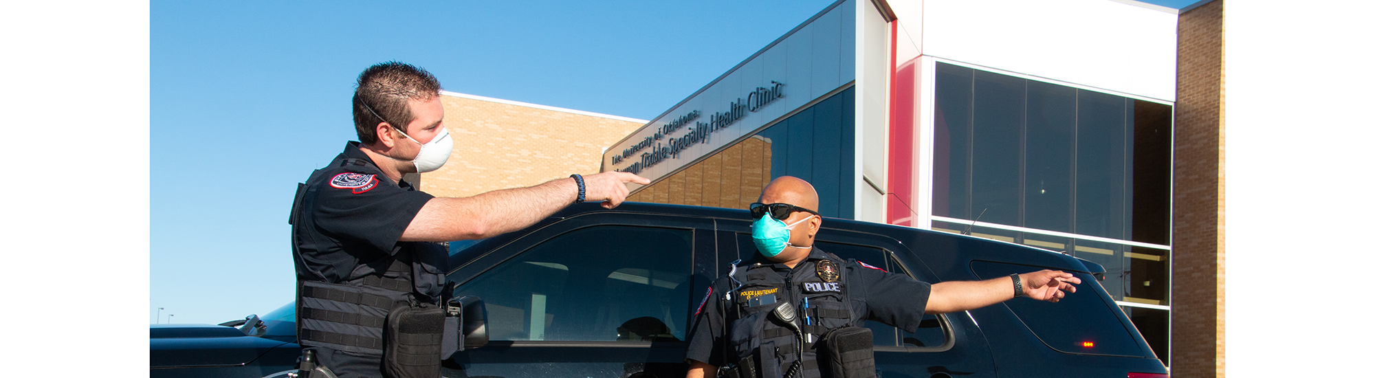 Officer Majed and Lt. Jacob in front of an OUTPD vehicle