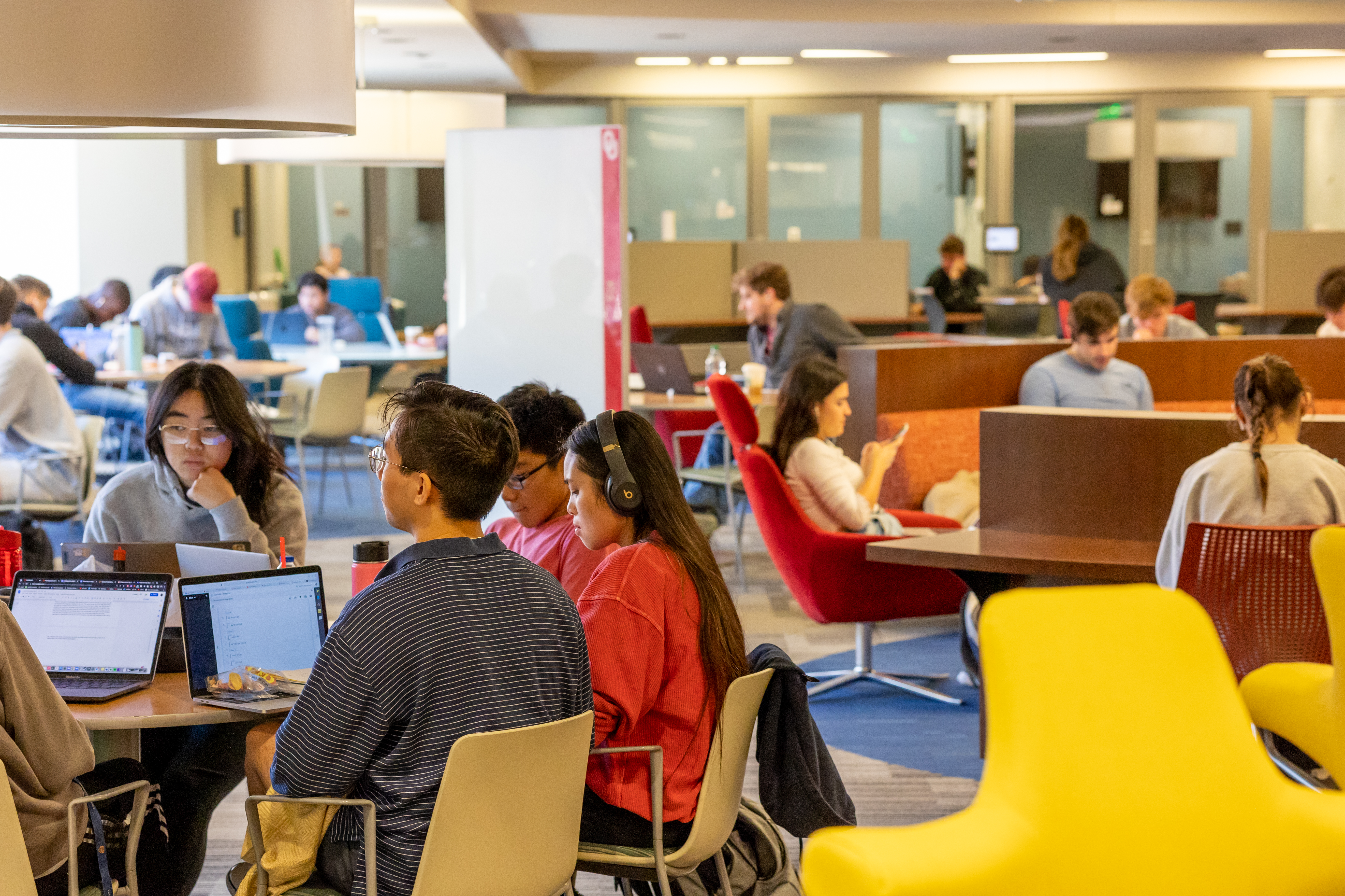 Students sitting in chairs in the library in study groups