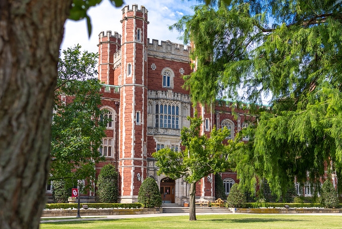 A shot of Bizzell Memorial Library through trees and greenery.