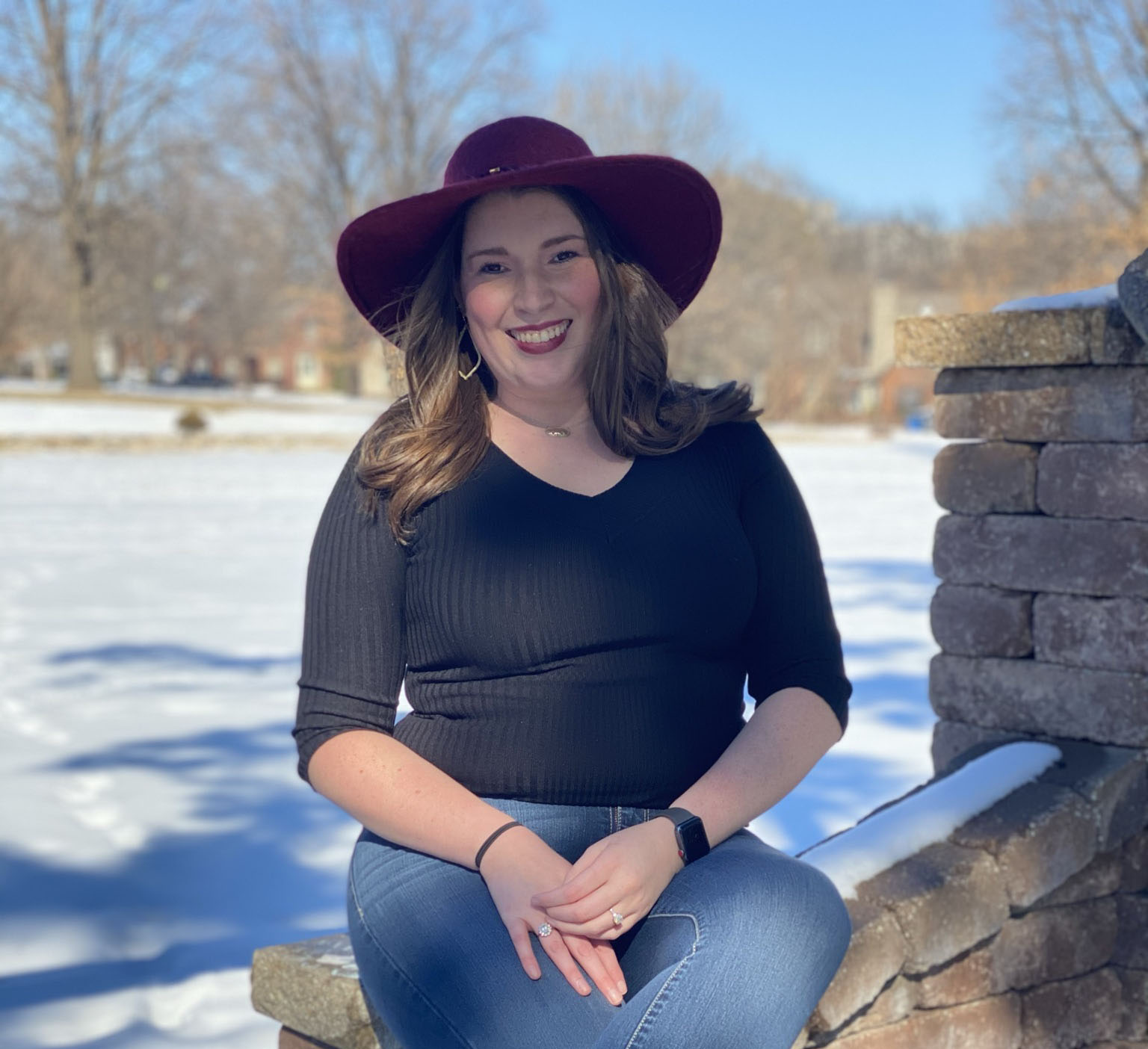 Megan McClellan sits on a stone fence