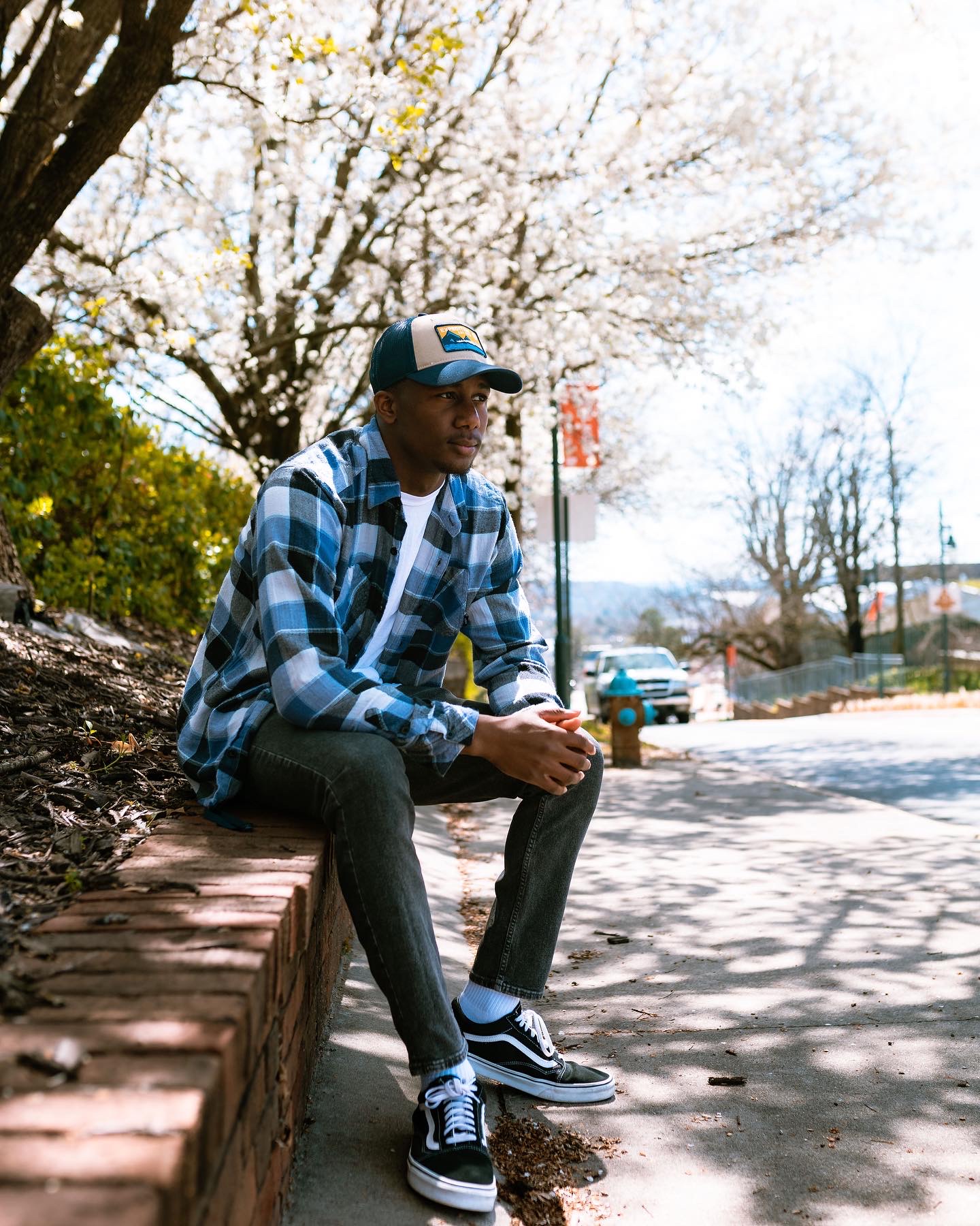 Braelon Palmer sits on a curb, staring into the distance.