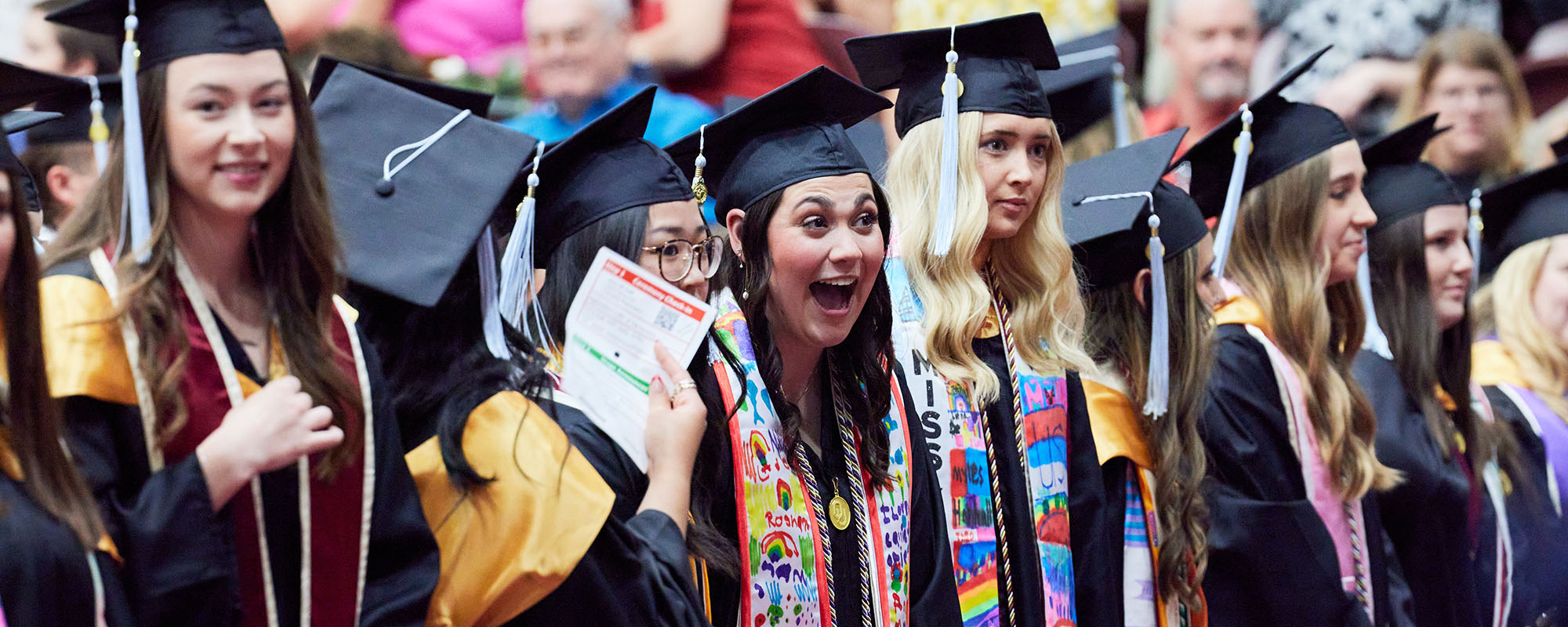 Graduates posing together during ceremony.