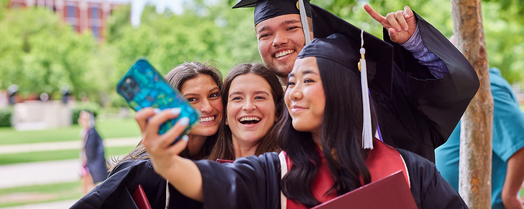 Graduates posing outside after graduation ceremony.