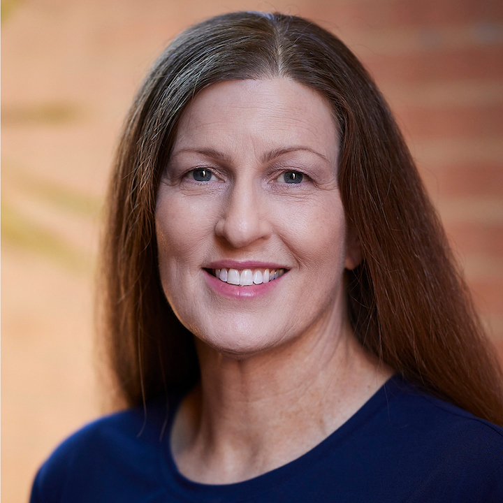 Woman with long brown hair in a blue top