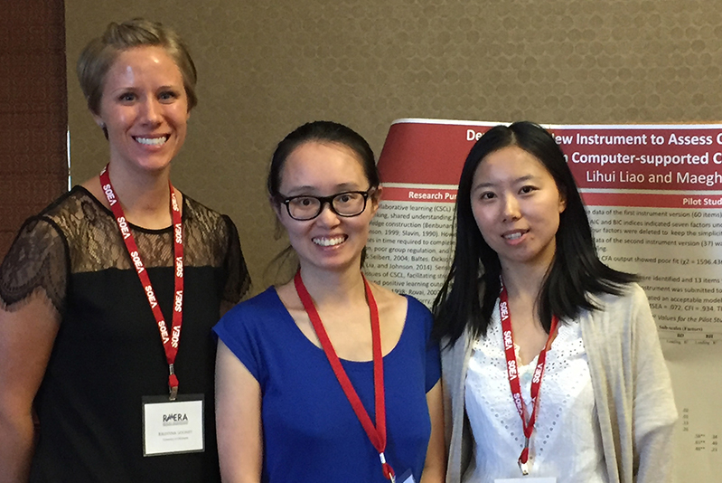 Three women standing in front of a presentation poster