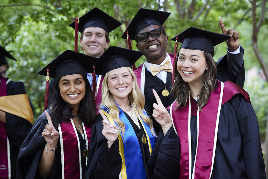 Five graduates in caps and gowns after Gaylord Convocation Ceremony.