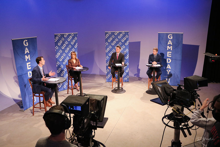 Four students in the studio for Gameday U with cameras around them.