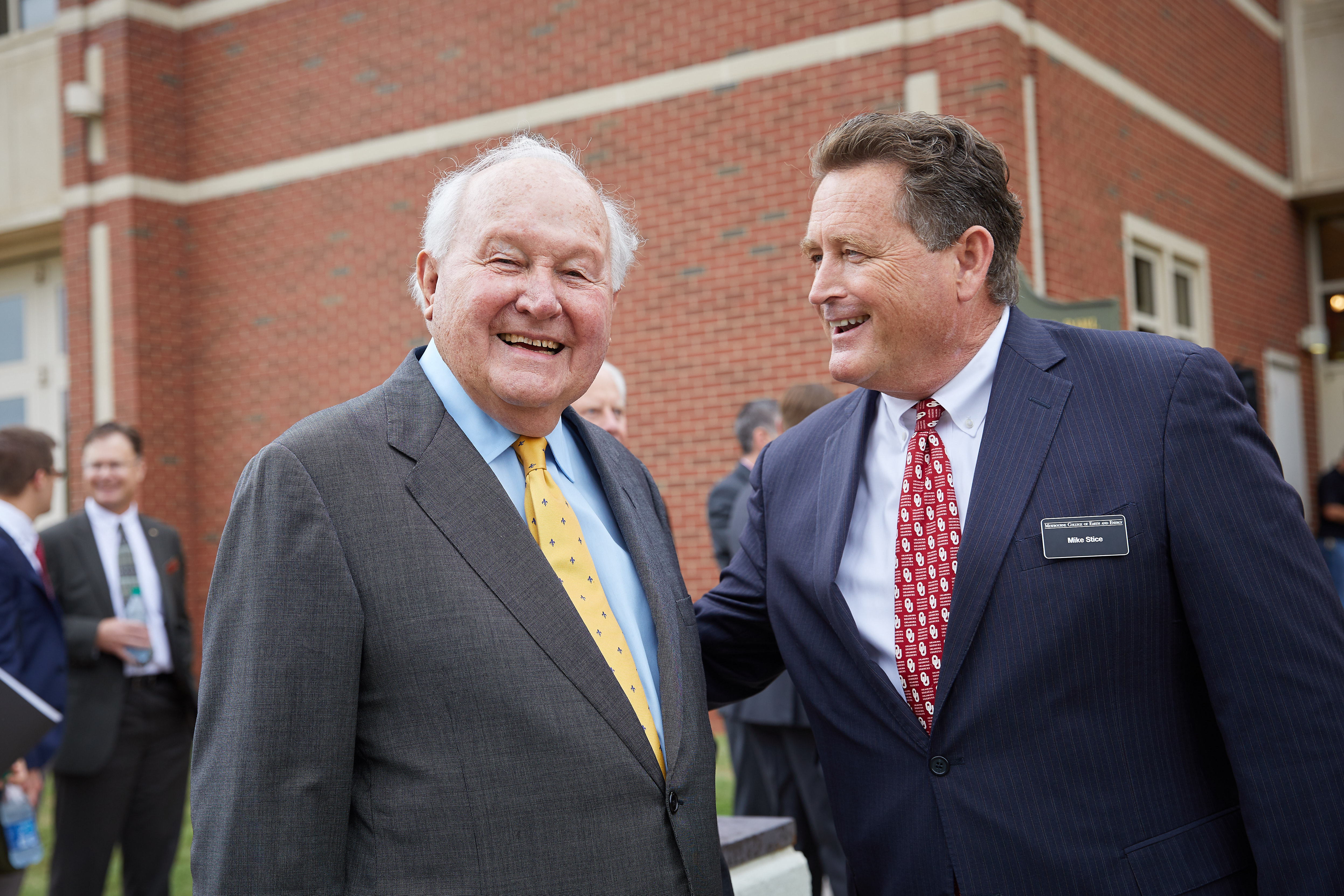 Dean Stice posing with Mr. Mewbourne in front of Sarkeys Energy Center.