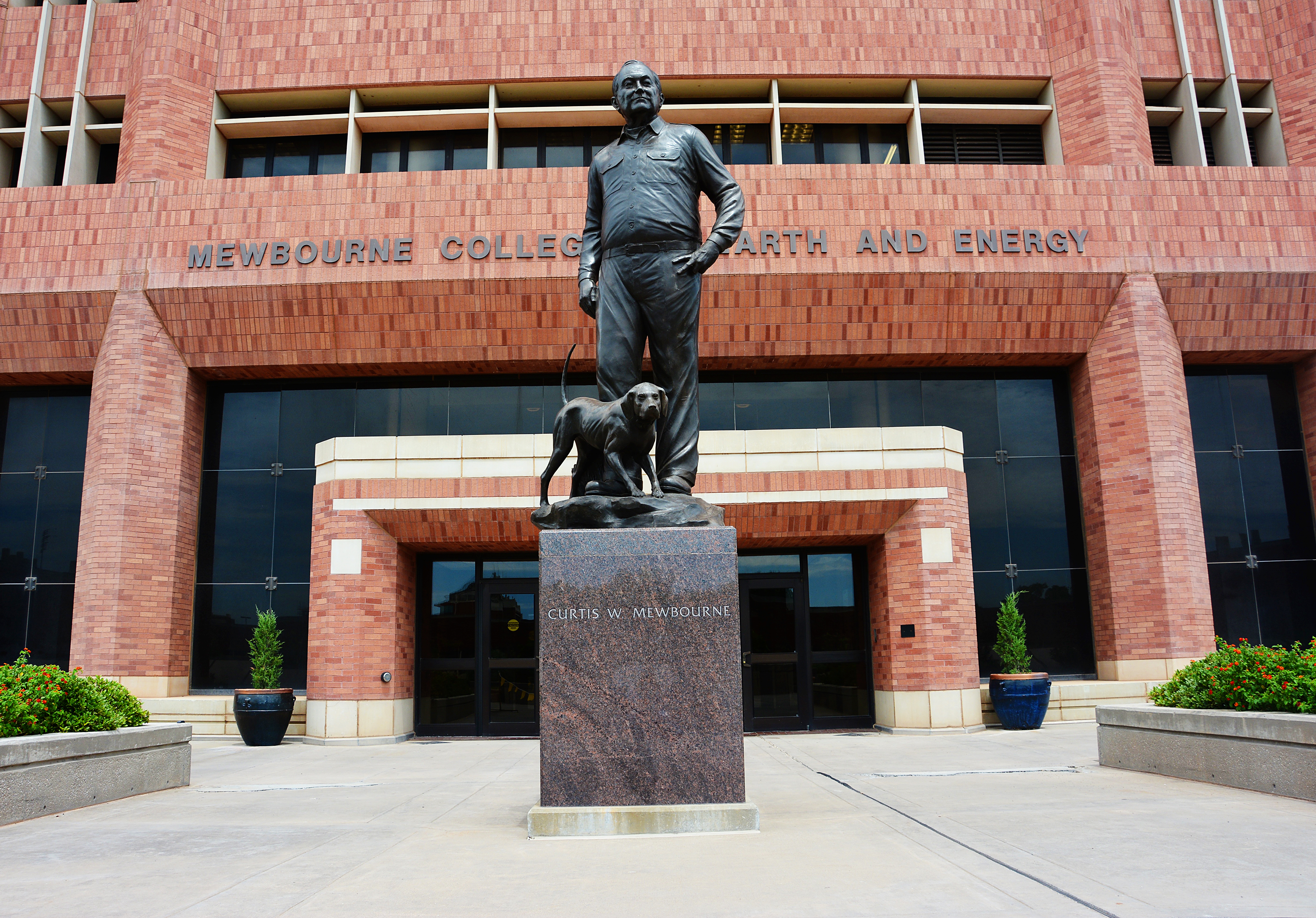 Mr. Mewbourne and his dog's statue outside of Sarkeys Energy Center.