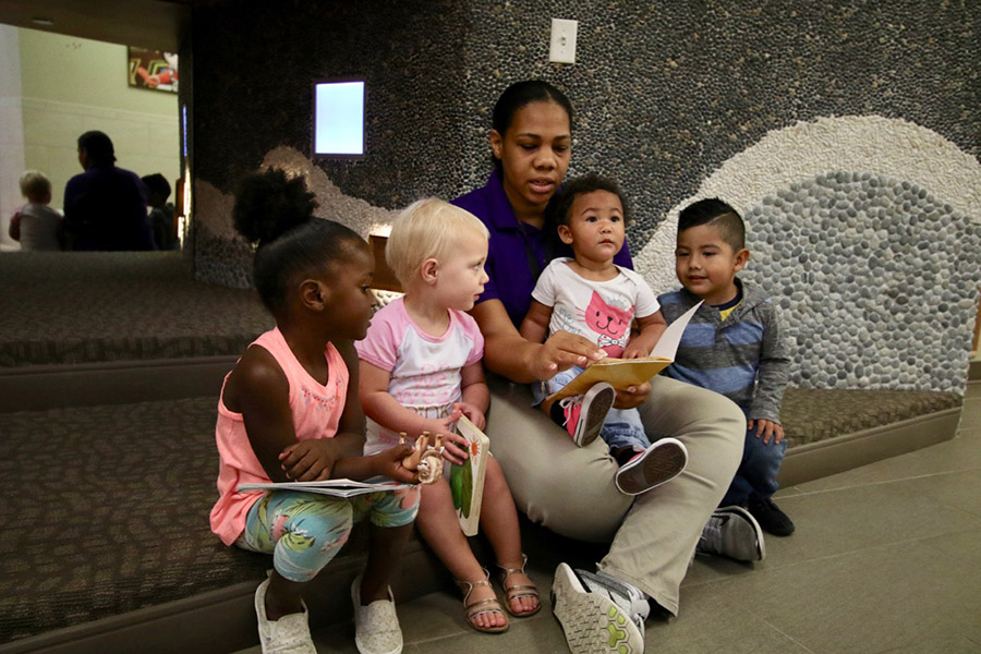 Children sitting with adult outside.