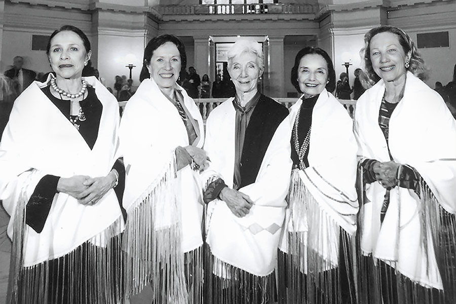 A black and white photo of the Five Moons ballerinas draped in shawls. 