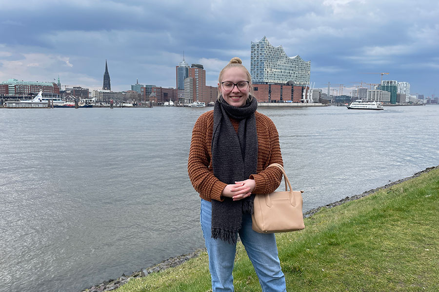 Colleen McLeish standing in front of a river and city skyline.