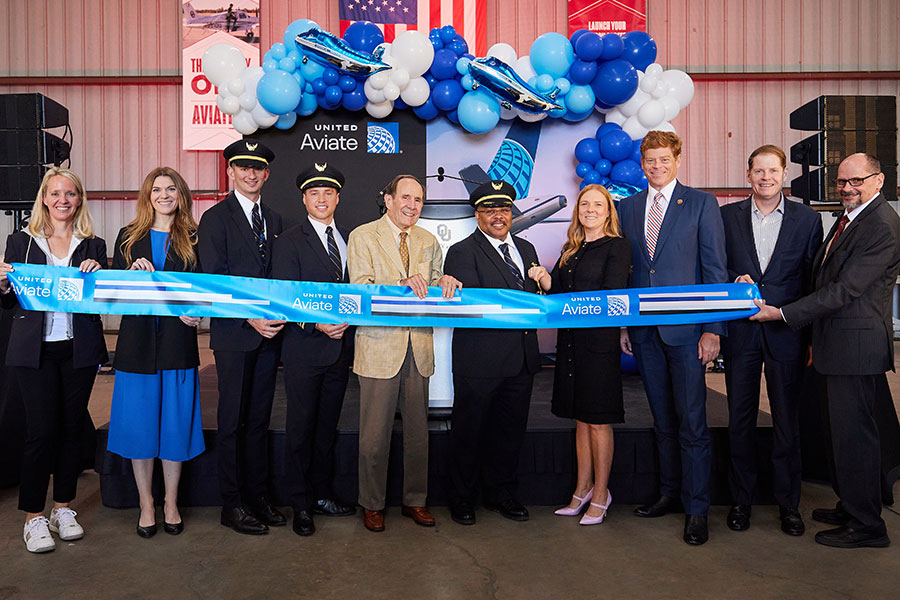 Representatives from the University of Oklahoma and United Airlines gather to cut a blue ribbon.