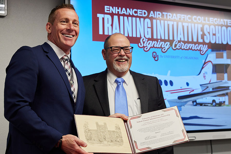 Chris Wilbanks and Mark Morvant holding the ceremonial signing document.