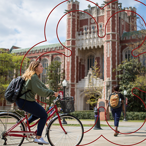 Student on bicycle on college campus.