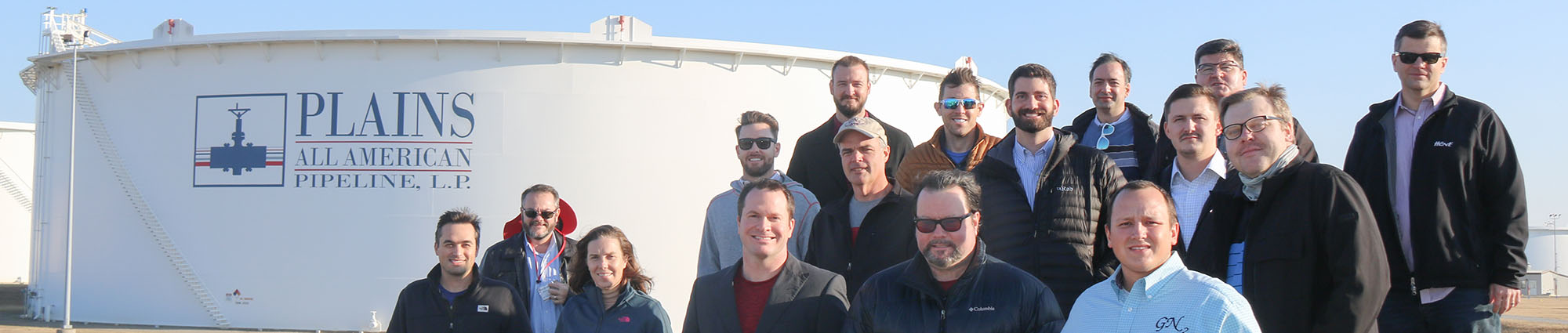 Executive MBA in Energy students stand in front of an oil storage tank in Cushing, Oklahoma.