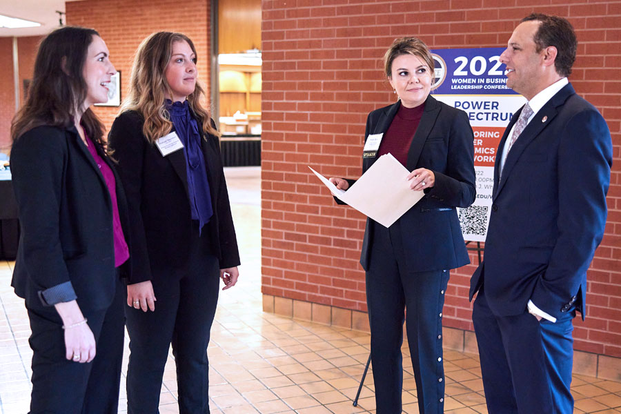 A JCPenney Leadership associate talks to the program director and president Harroz about logistics for an event.