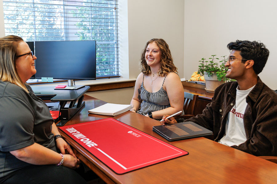 Two students sit side by side during a conversation with a team member in the Center for Student Success 