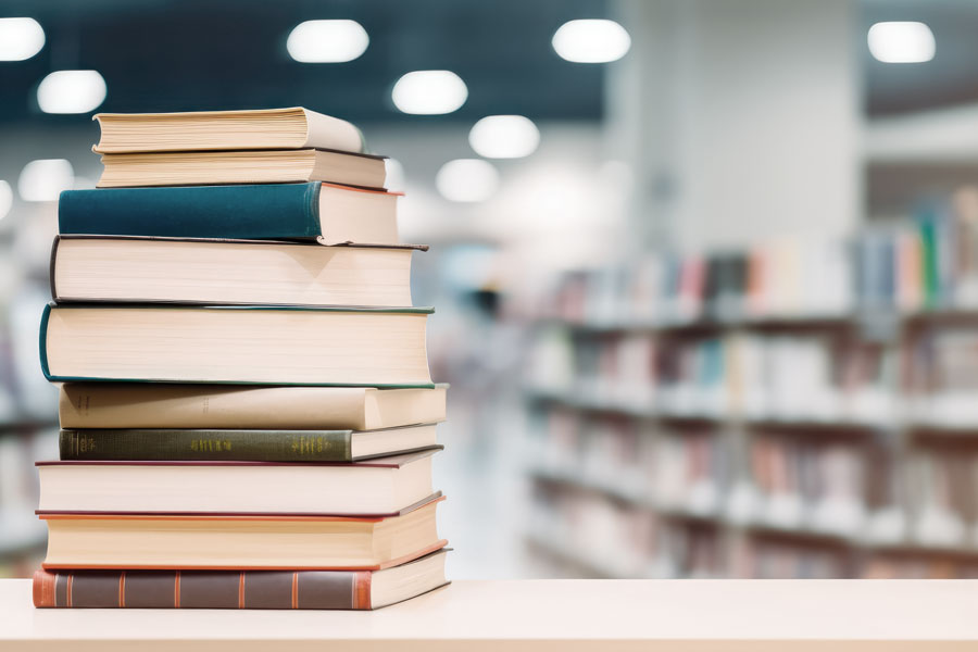 a stack of books on a table in a library.