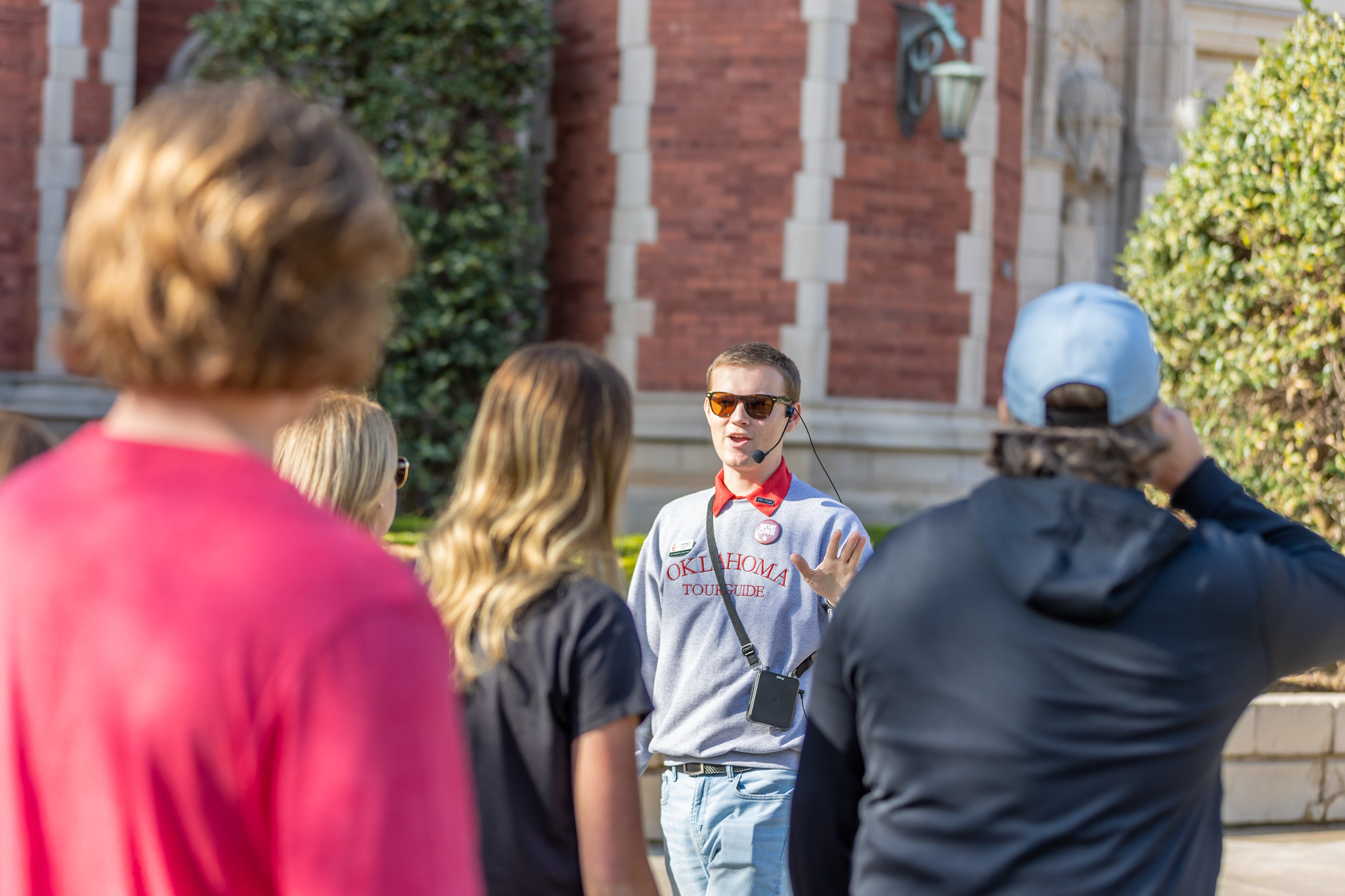 Student tour guide leading students and a family on a tour through campus.