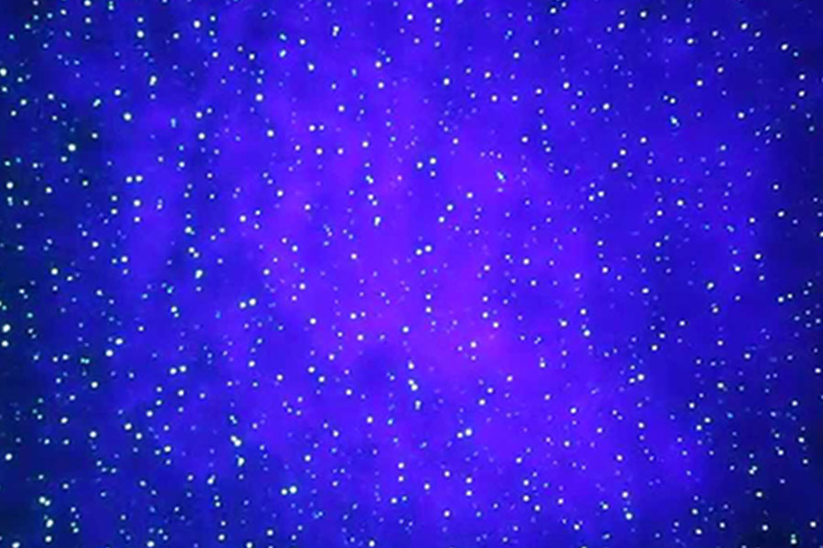 A purple/pink light shining with many blue dots throughout the image.