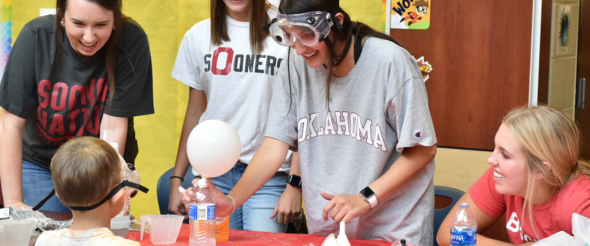 OU students interact with children at a science fair