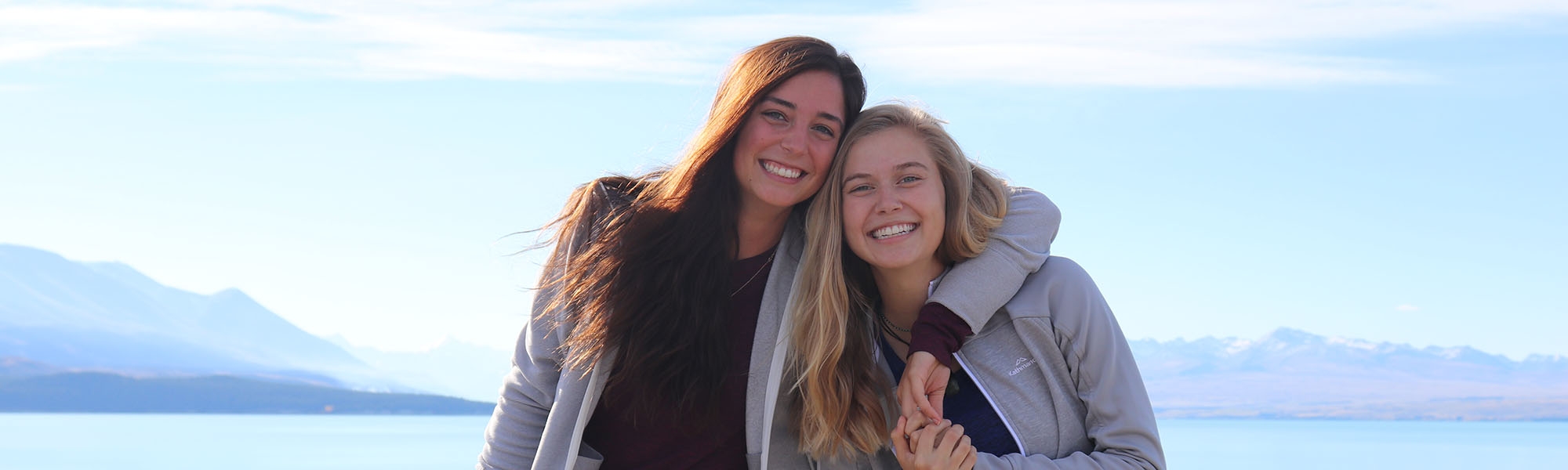 Students posing together in front of ocean