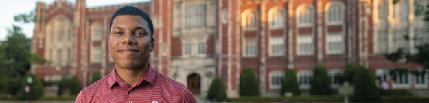 male student standing in front of evans hall