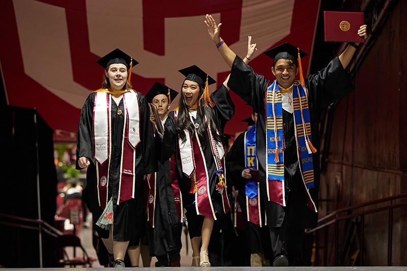 Group of students celebrate as they walk down the tunnels to the exit at LNC