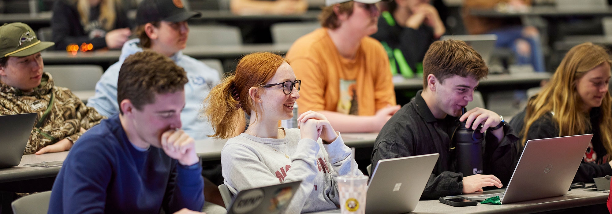 Students sitting in a classroom with laptops.