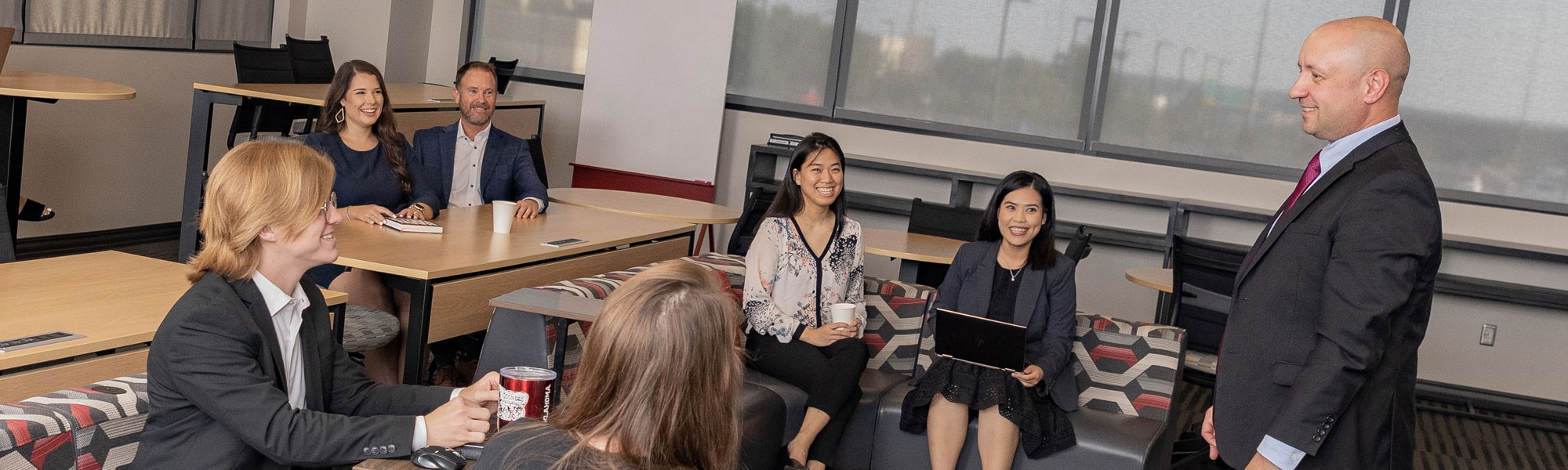 A professor addressing a group of adult students in a classroom at the Gene Rainbolt Graduate Center.