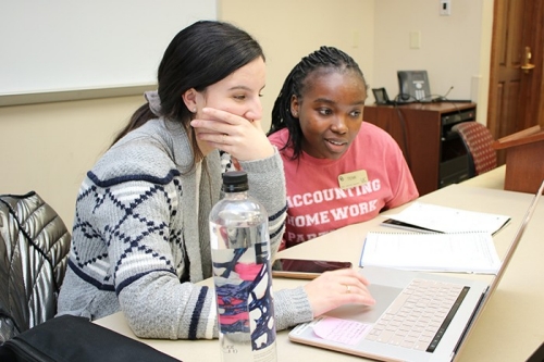 two students working together on a laptop computer