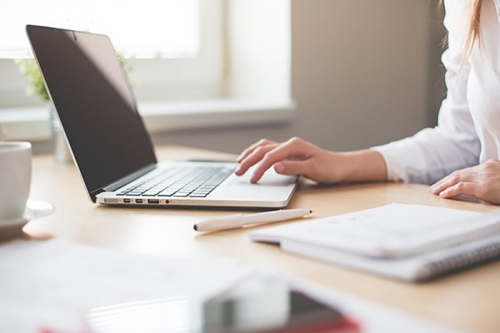 closeup photo of a woman typing on a laptop