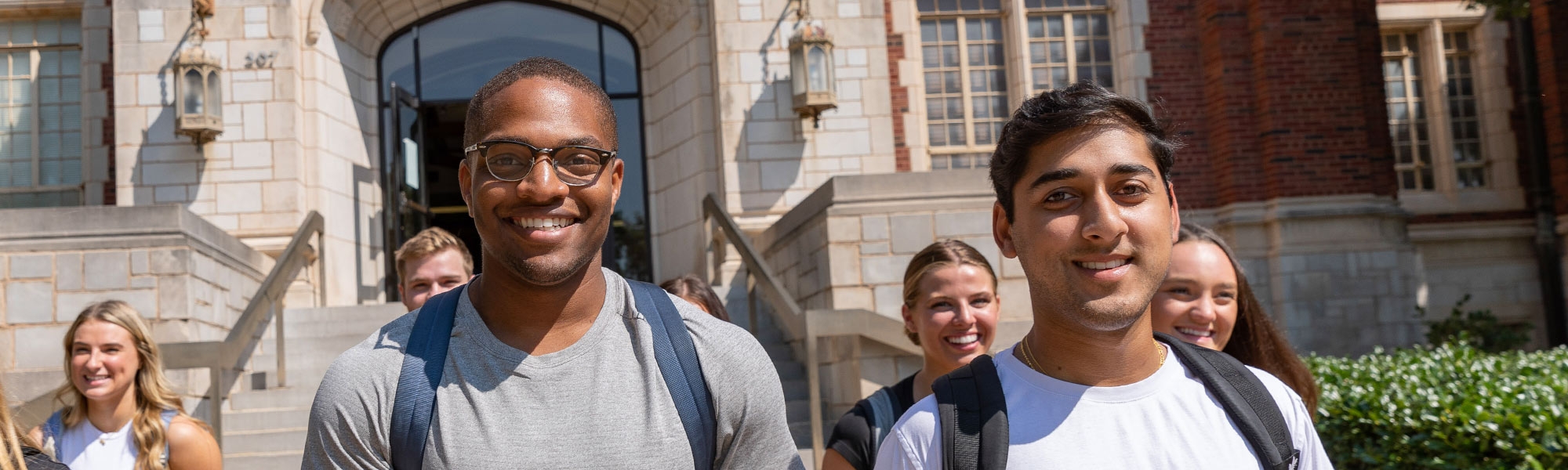 Several students exiting down the front steps to Adams Hall.