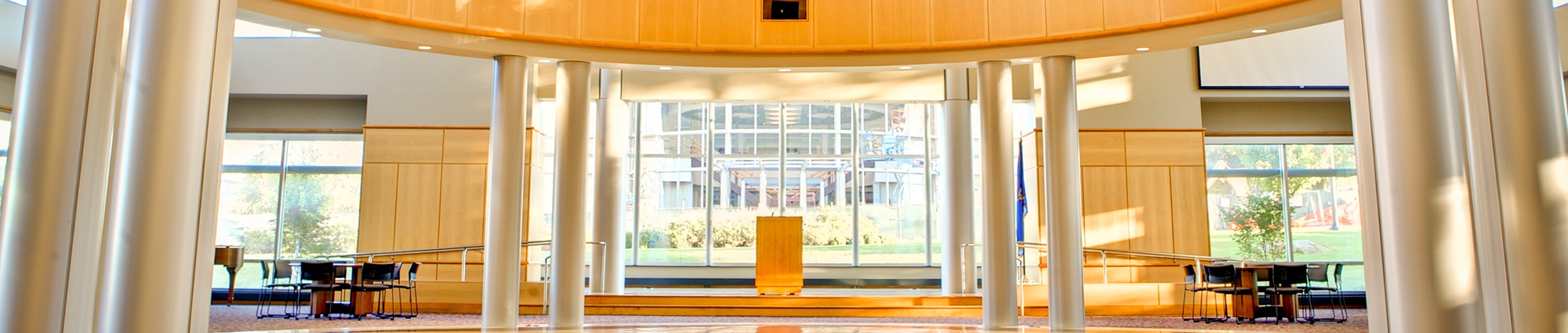 A wide, sunlit space with brown and tan flooring that gleams in the sun