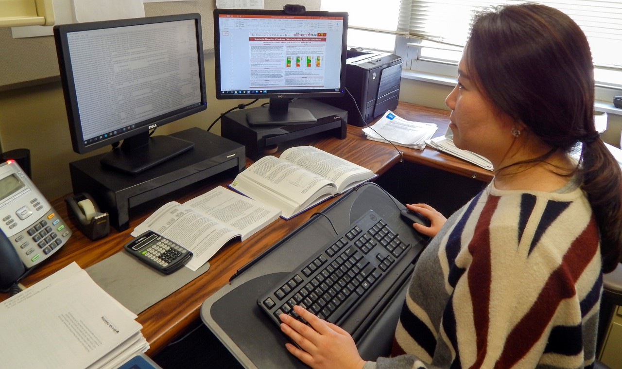 A woman works at a computer.