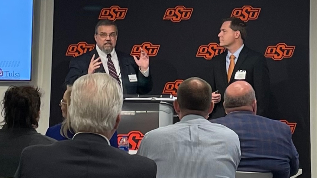 Two men present at a lectern