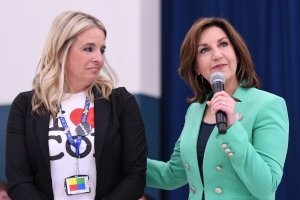 Aubrey Flowers looks on as a speaker speaks into a microphone