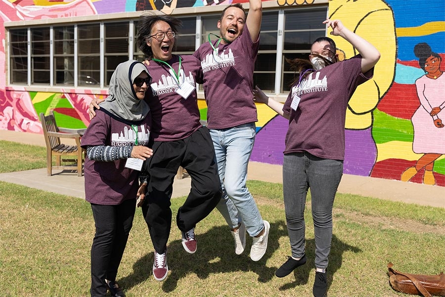 Four students jumping and having fun at the Tulsa summer Institute.