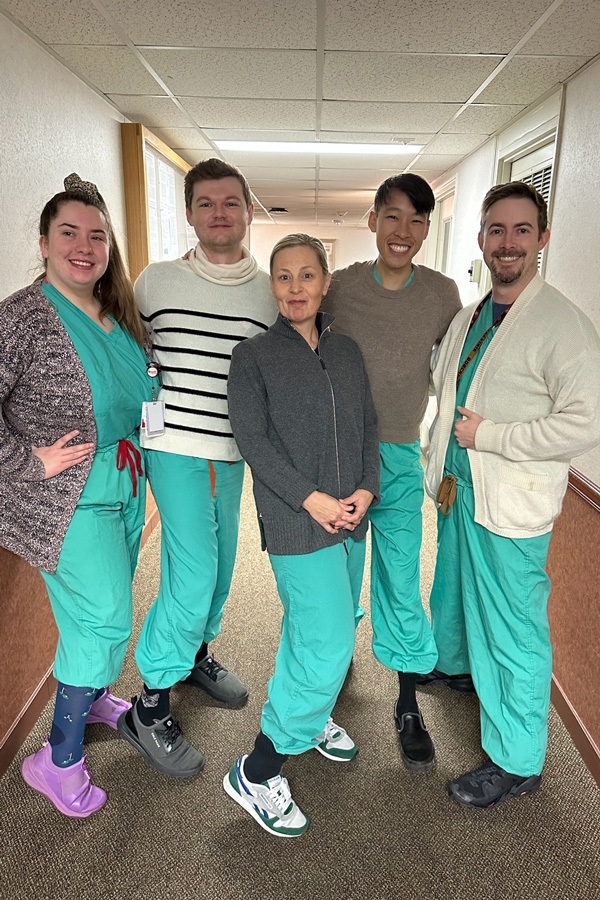 Wellness residents in scrubs and masks.